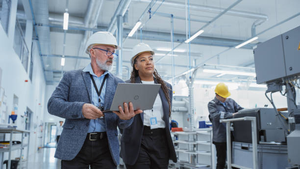 Man and woman walking through manufacturing plant